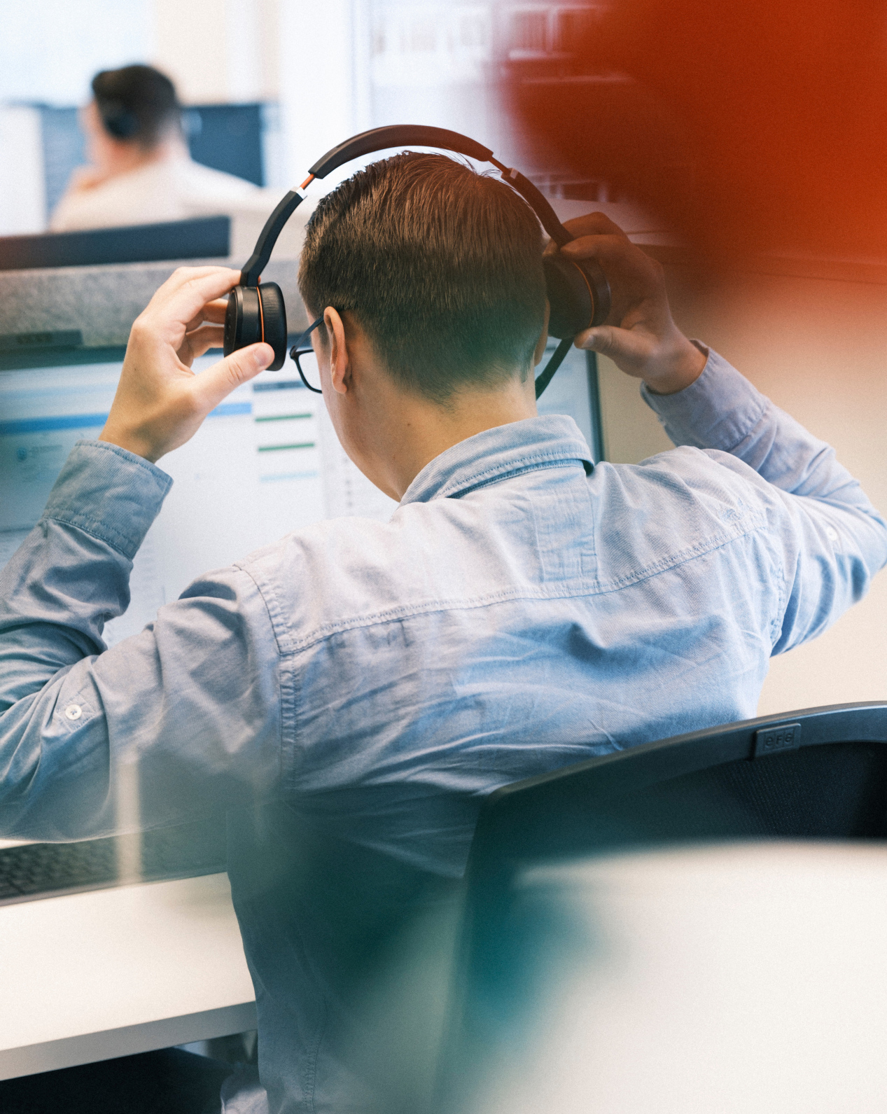 Man sitting in front of screen with headset