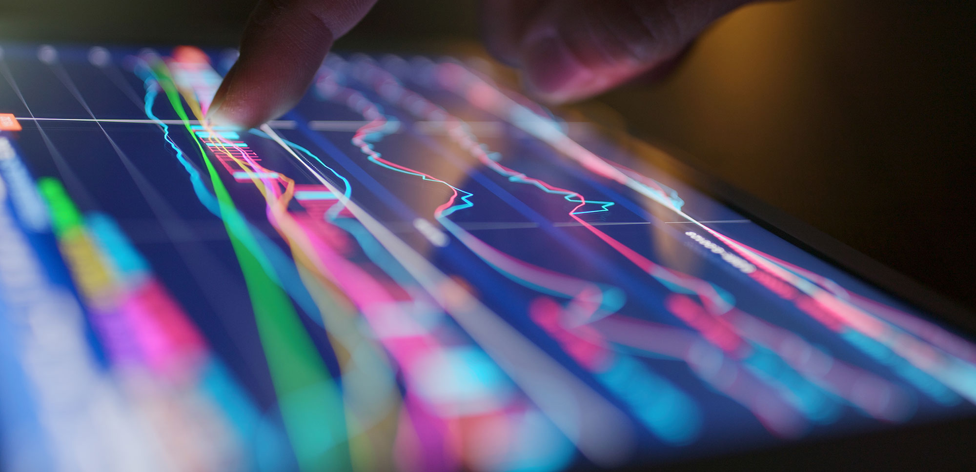 person pointing to ipad with graphs